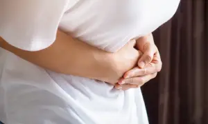 Osoba trzyma się za brzuch, odczuwając ból pod lewym żebrem.