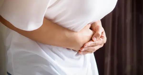 Osoba trzyma się za brzuch, odczuwając ból pod lewym żebrem.